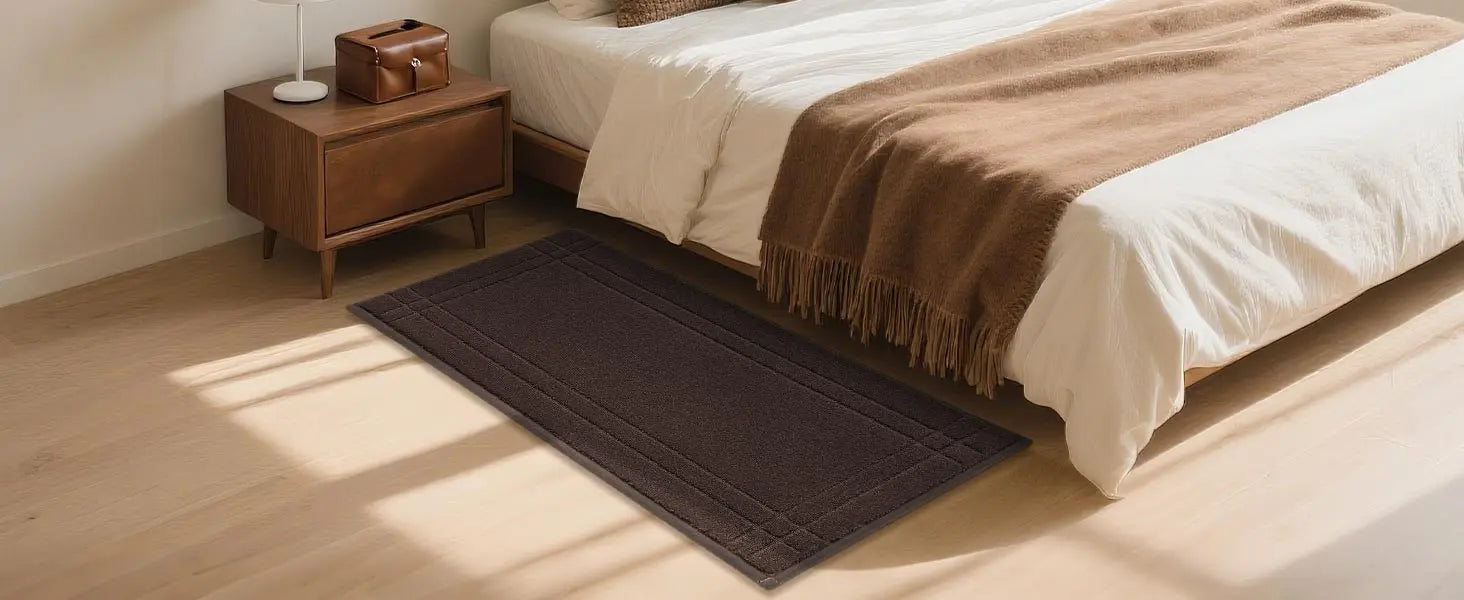 Bedroom with a brown blanket, and wooden nightstand.